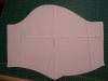 A paper pattern for a short sleeve with a dart in the centre and a curved hem.