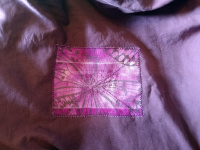 A purple sheet with a pink butterfly-print patch sewn onto it.